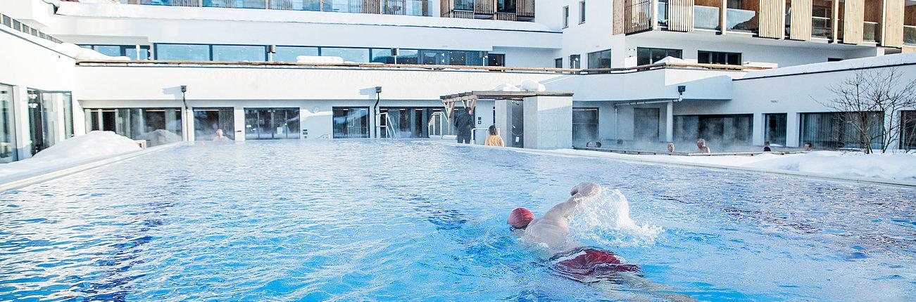 Schwimmer im Außenpool schwimmt eine Bahn