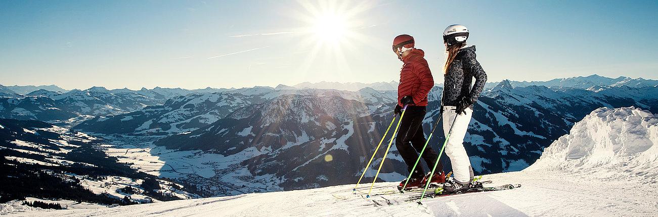 Zwei Skifahrer genießen die Aussicht im Sonnenschein