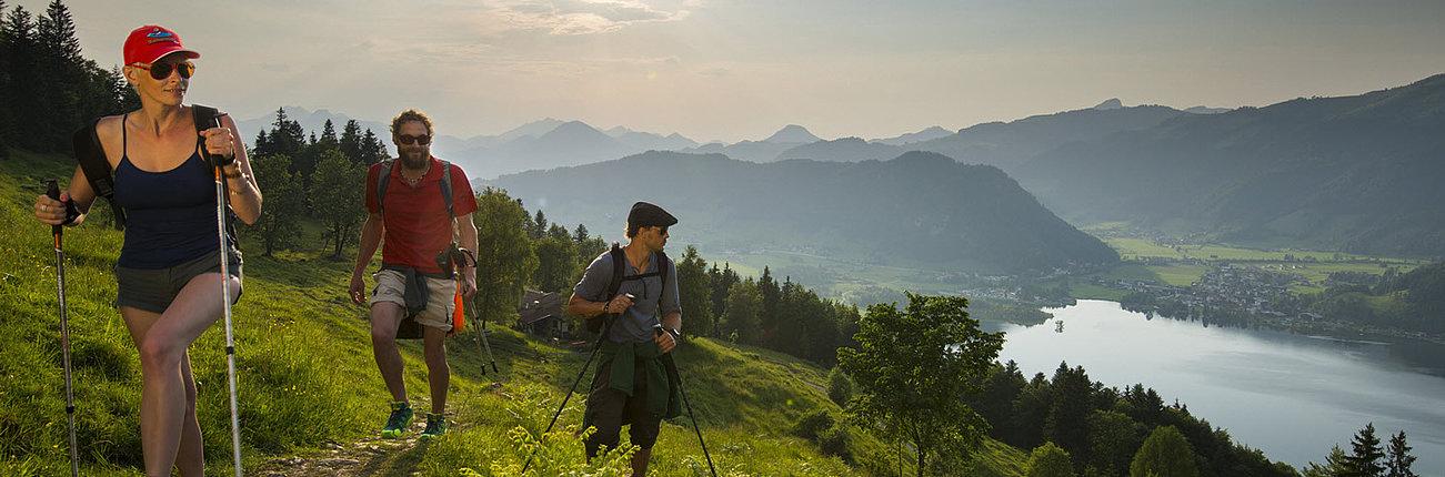 Dreiergruppe wandert mit Aussicht auf den Walchsee