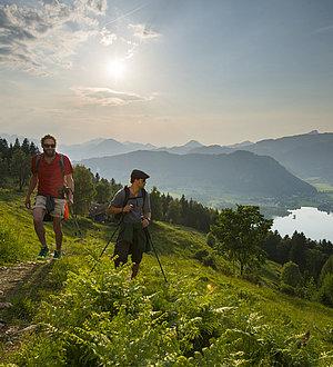 Group of three people hiking while enjoying the views to Walchsee