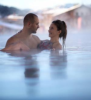 Pärchen blickt sich verliebt im Innenpool an